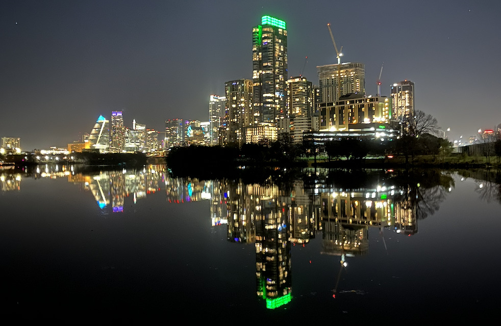 Austin's skyline shimmers in serene nighttime reflection.