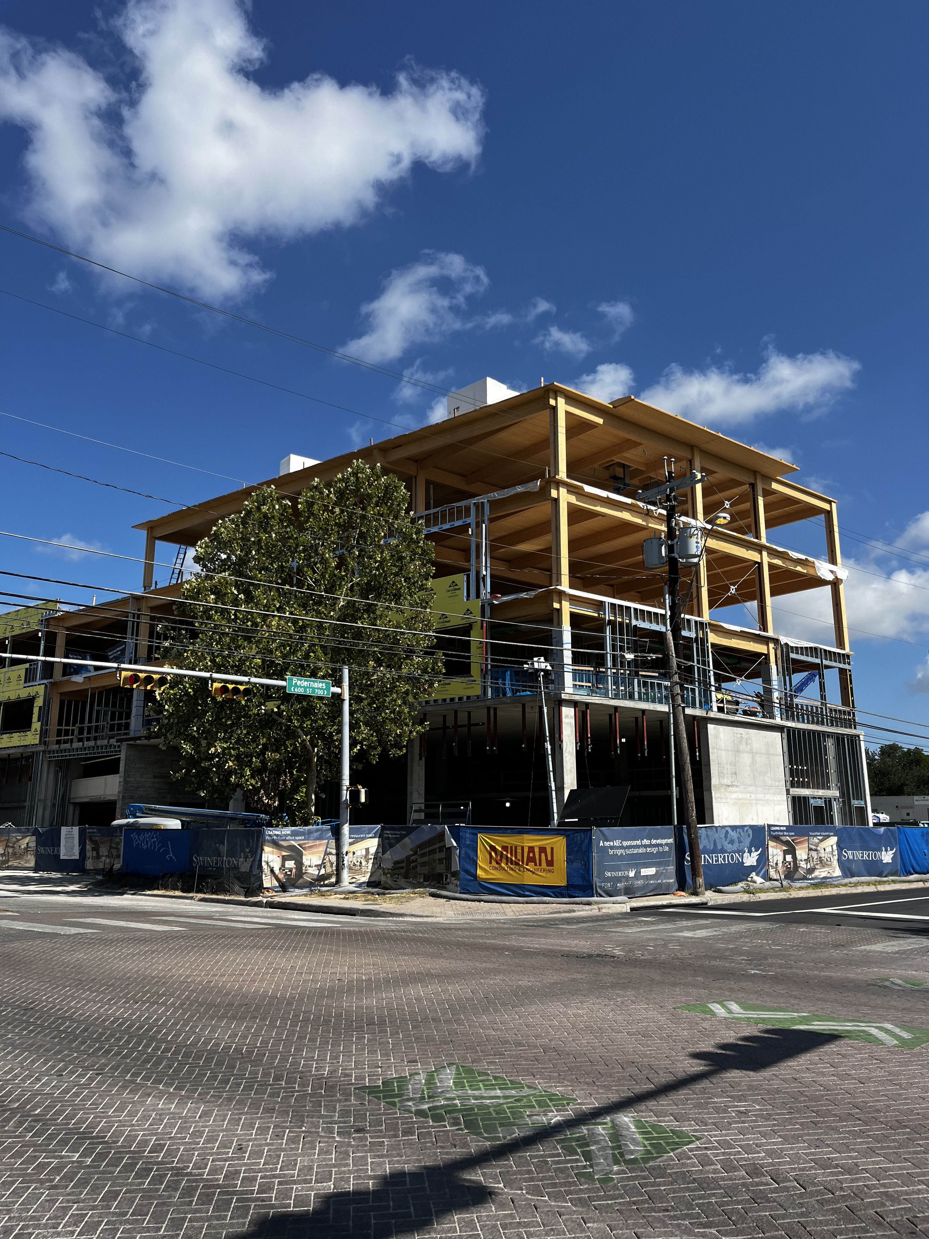 Wood framing rising, structures connect, infrastructure integrates.