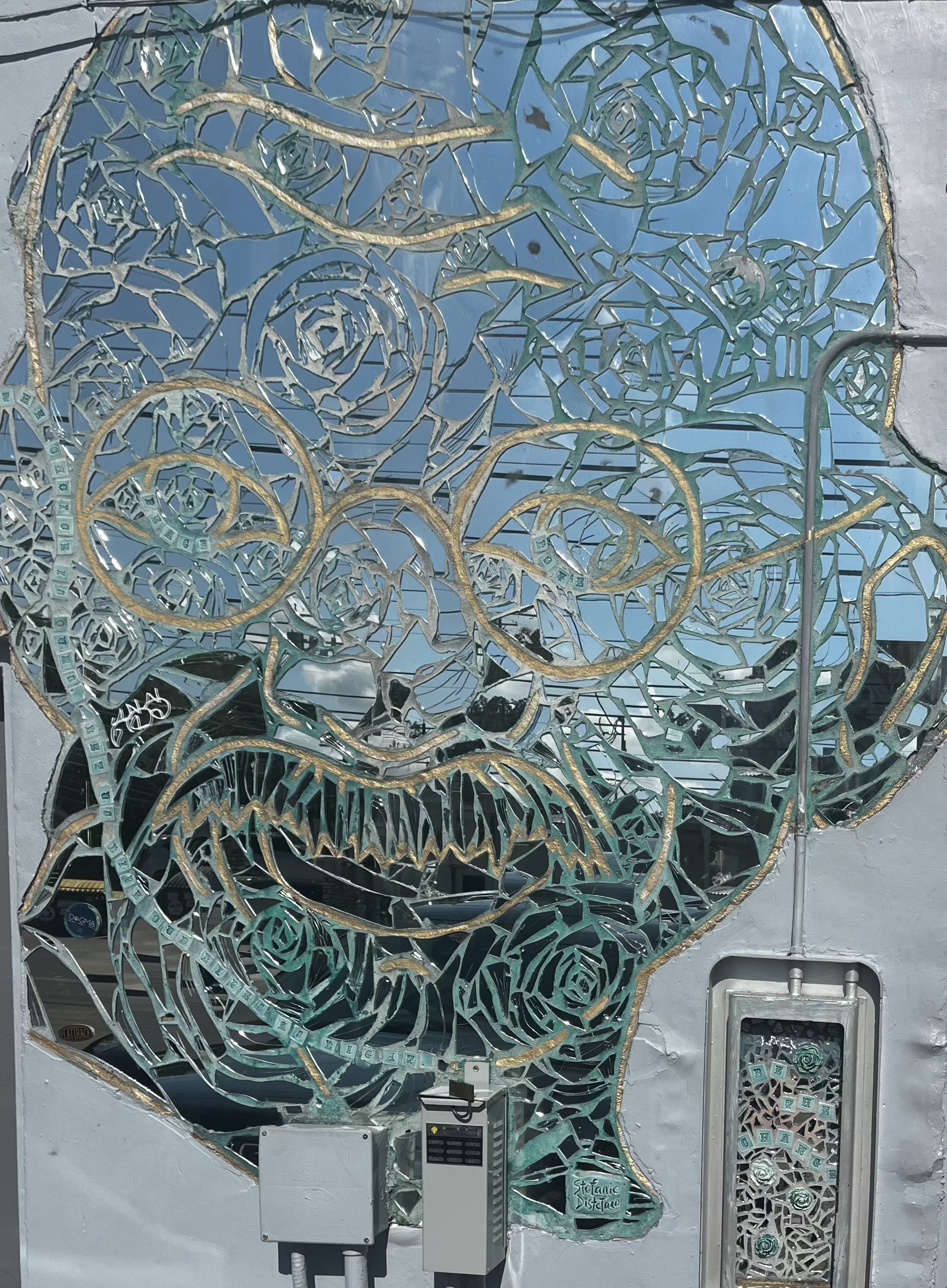 Whimsical mirror mosaic, reflecting urban skies. 