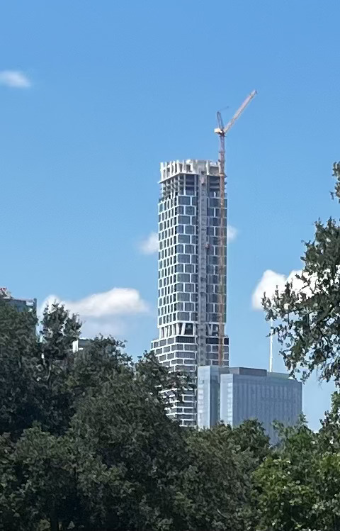 Construction continues: High-rise building nearing completion.