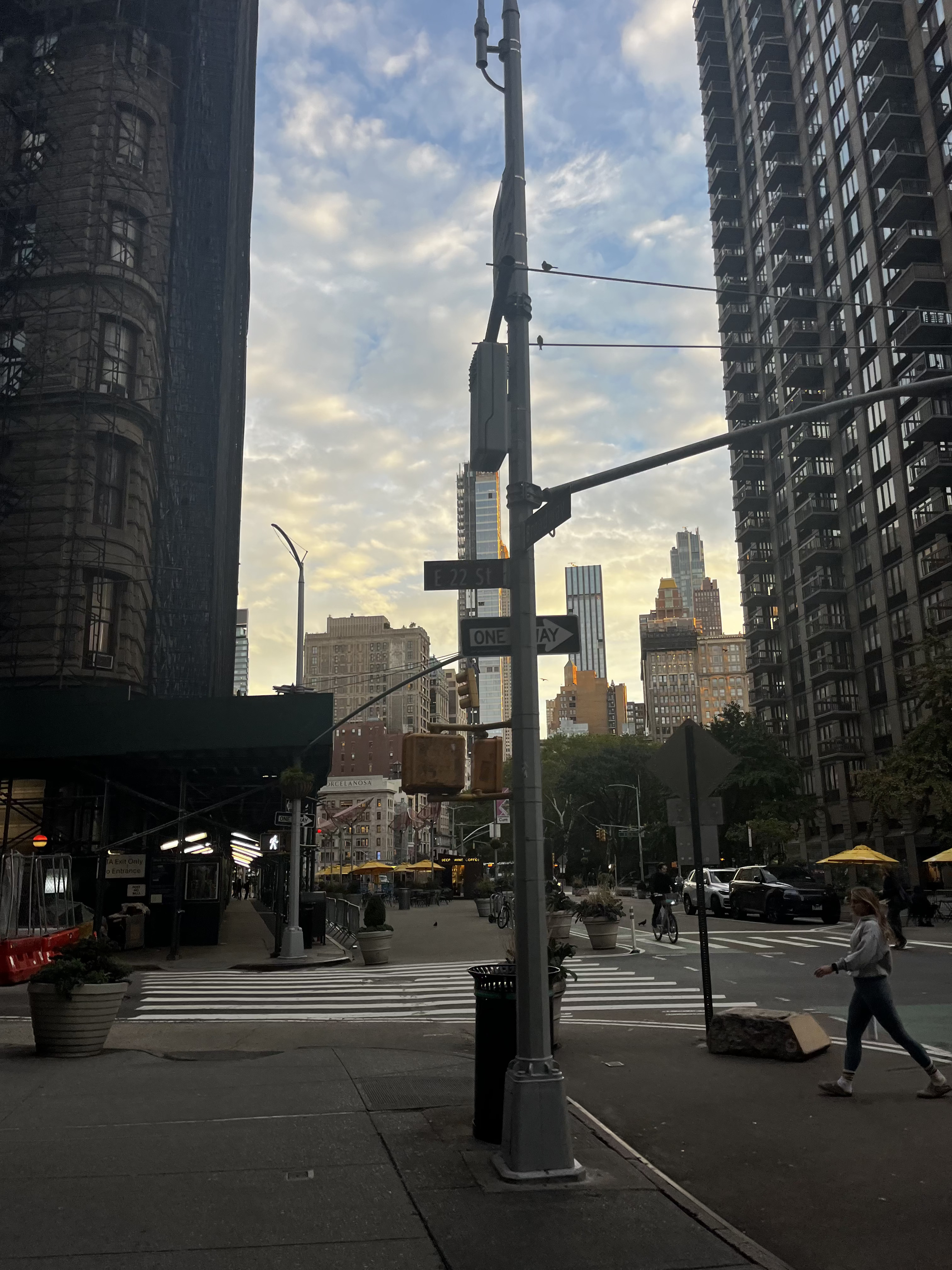 NYC crosswalk: Buildings rise, life moves, sky glows.