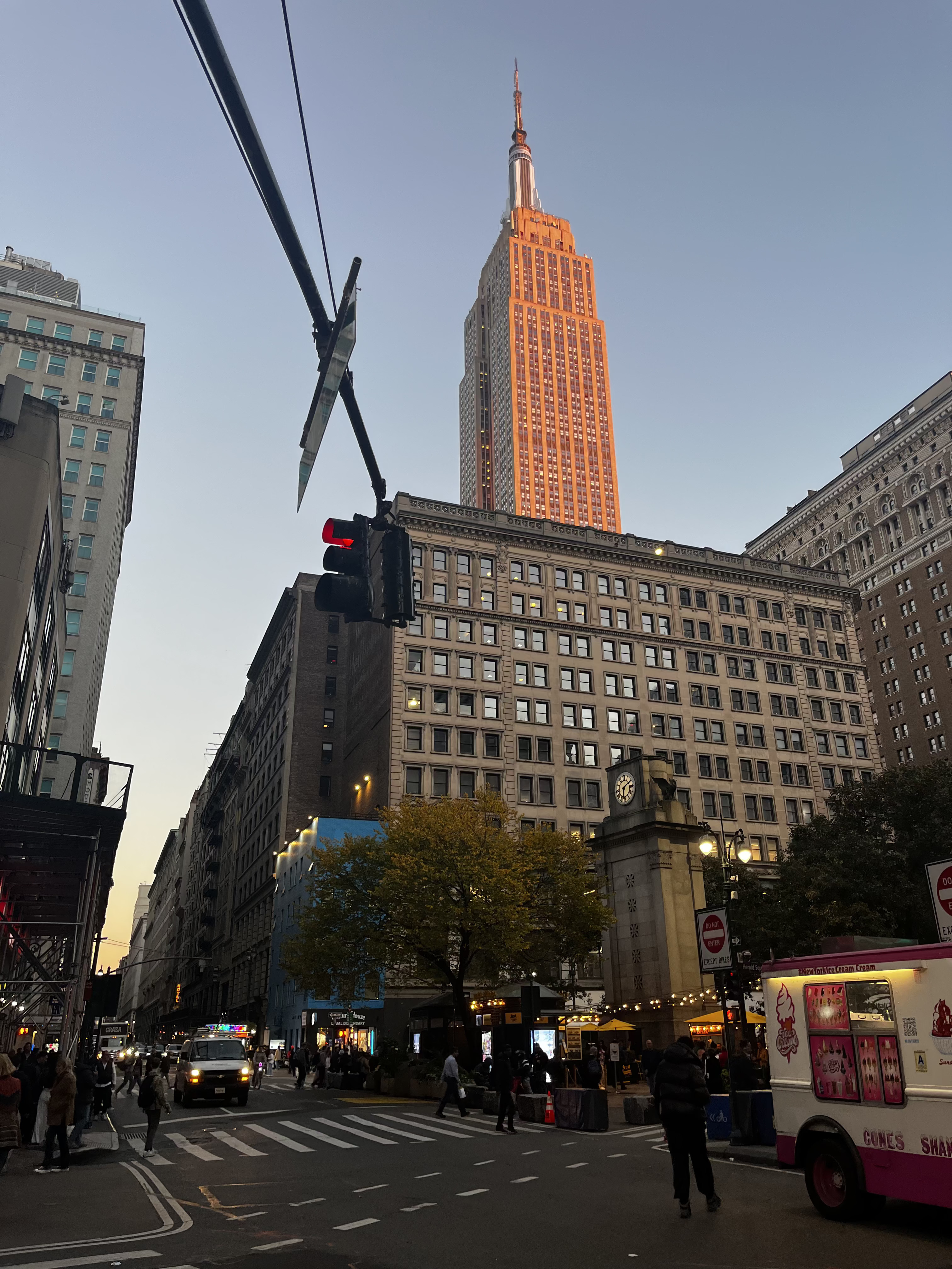 Empire State Building overlooks a bustling New York City street.