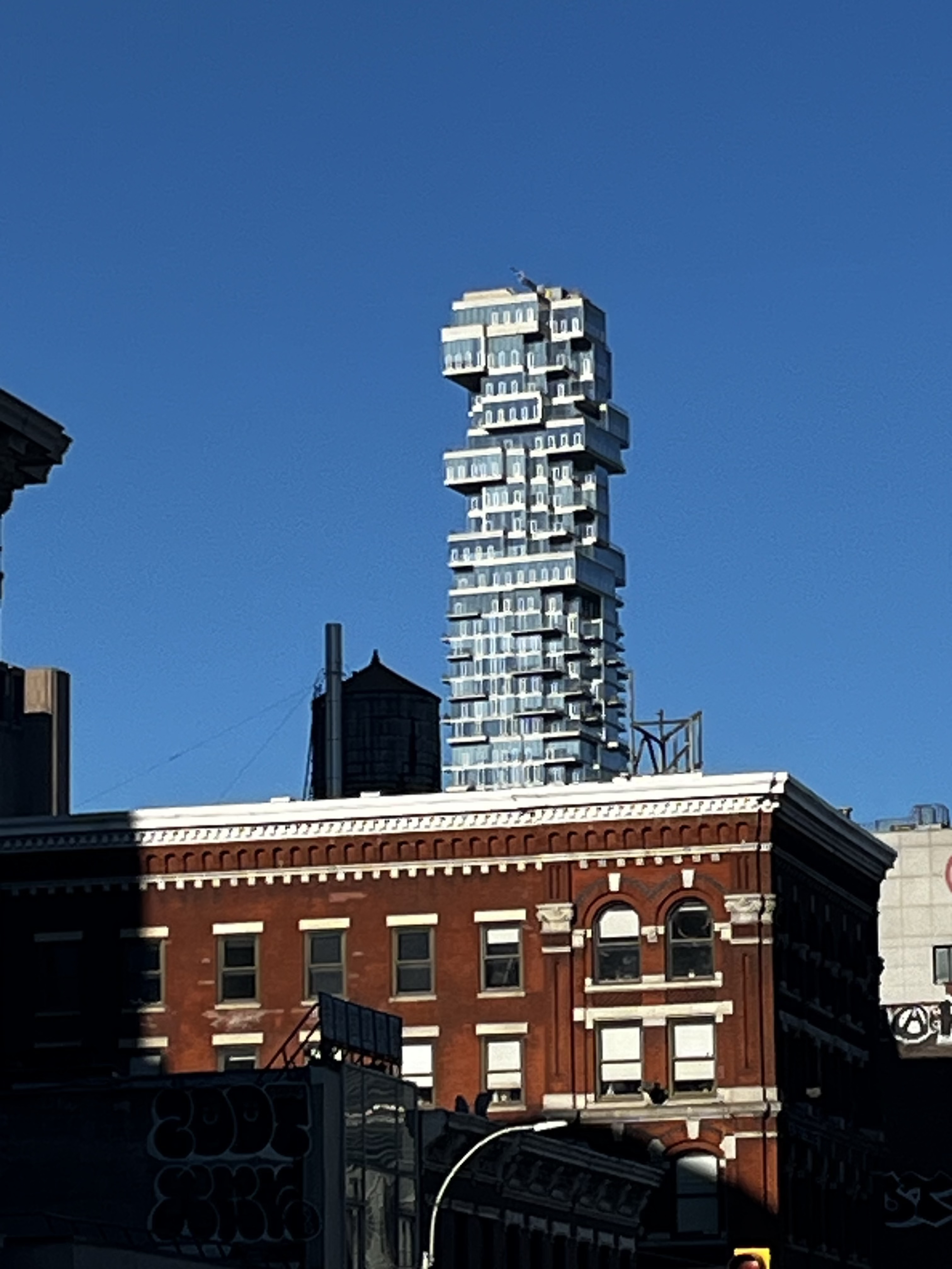 Unique tower rises above traditional architecture on sunny day.