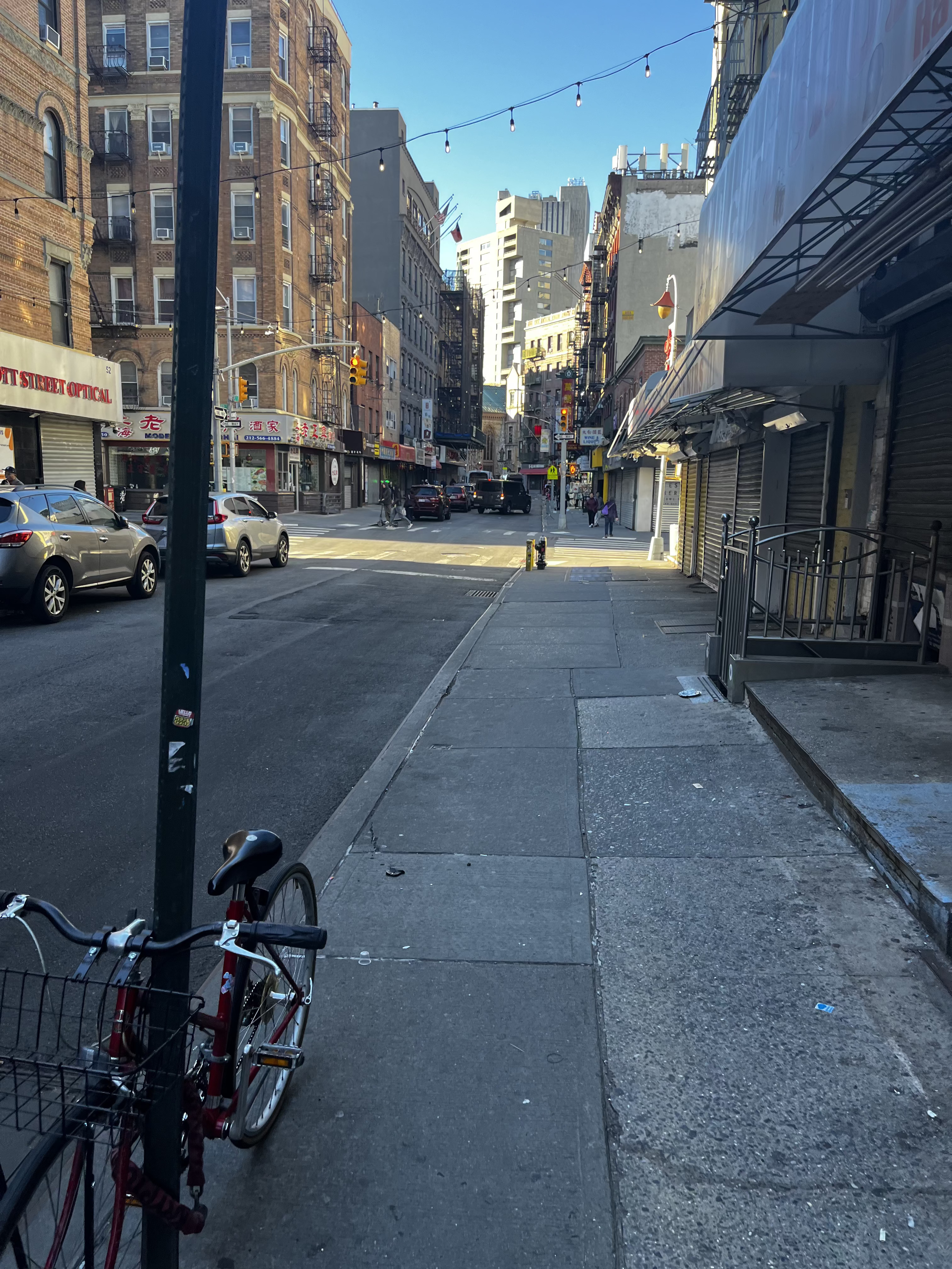 Urban scene with parked bicycle, sidewalk, and buildings.