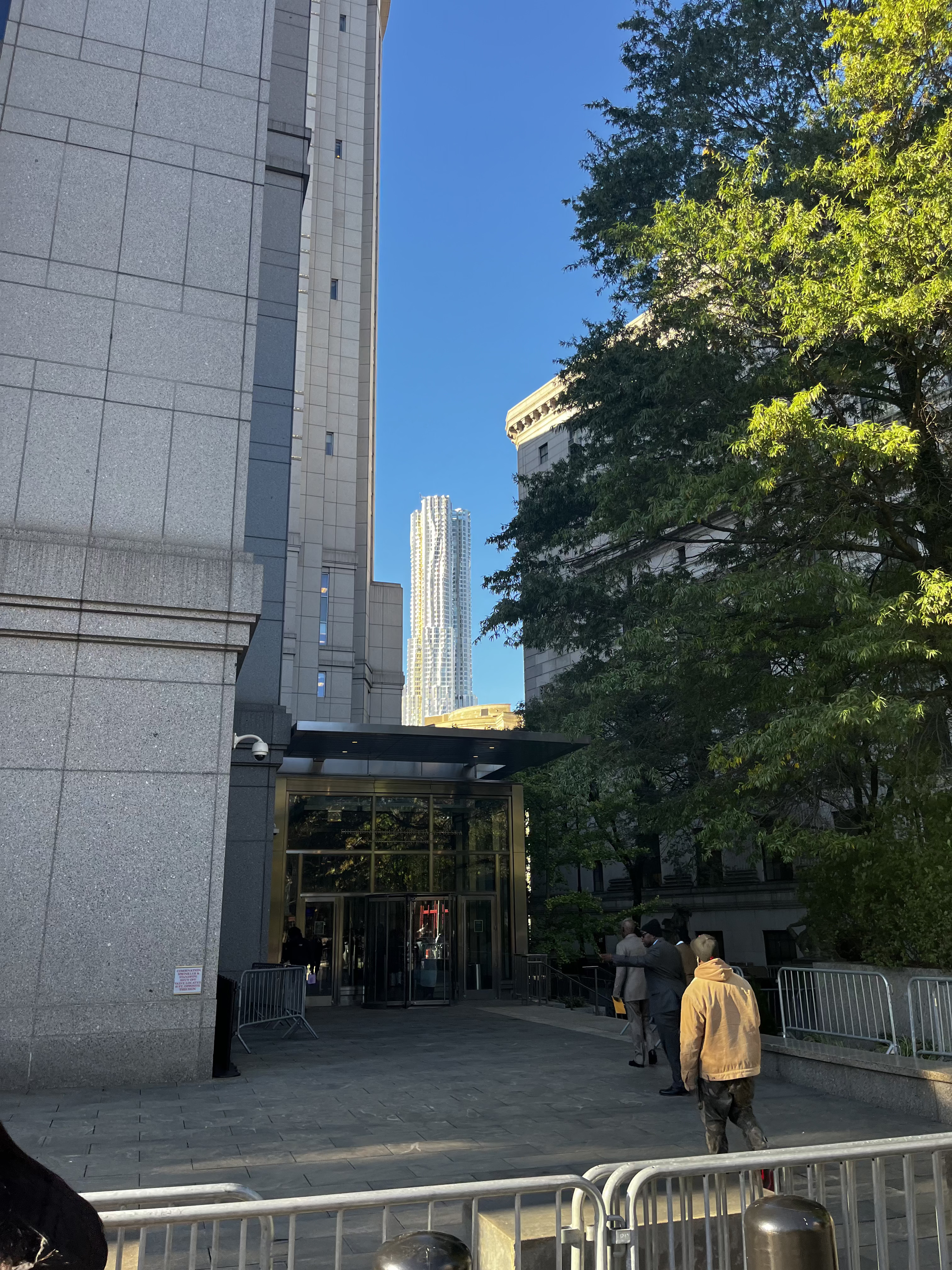 Waiting outside the building, skyscraper in the background.