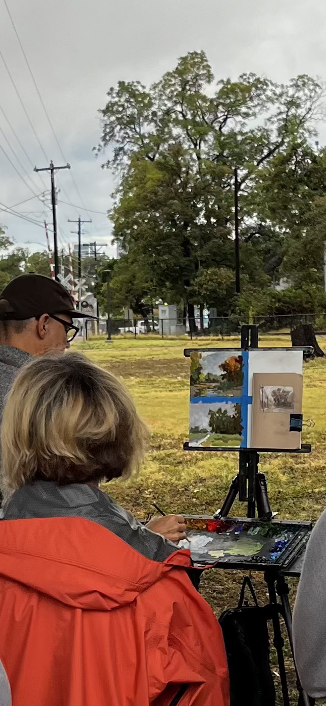 Artists painting outdoors, capturing nature's beauty on canvas.